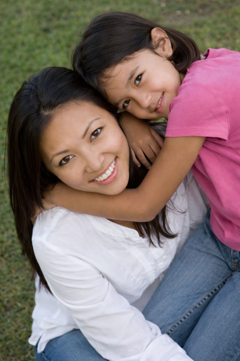 Mother and daughter embrace outdoors